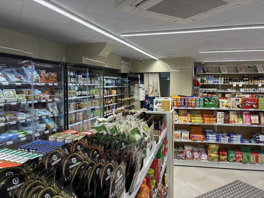 Allée centrale et réfrigérateurs de l'épicerie Yommi Mart
